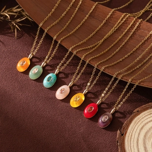 Detail of colorful water drop pendants in titanium steel with 18k gold plating and zircon
