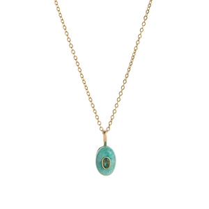 Macro detail of oval turquoise pendant with green gemstone on a thin gold necklace chain
