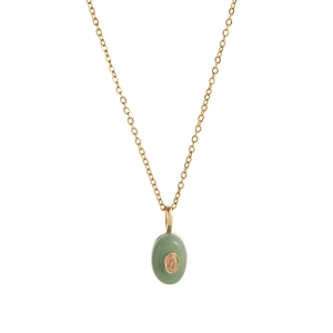 Macro detail of 18k gold plated chain with green stone teardrop pendant and amber center