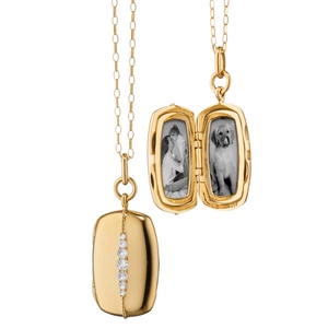 Detailed macro view of 18K gold rectangular locket necklace with five sparkling gemstones