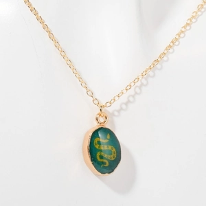 Vintage gold necklace featuring a dark green oval pendant with an intricate gold snake motif