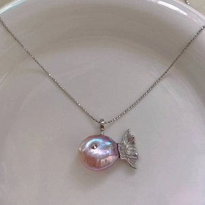 Macro shot of pink baroque pearl fish pendant with silver fish tail and bead chain