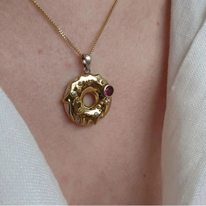 Gold donut pendant necklace with colorful zircon gemstones on a delicate chain