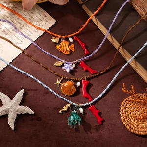 Detailed close-up of starfish and jellyfish pendants with colorful woven necklaces