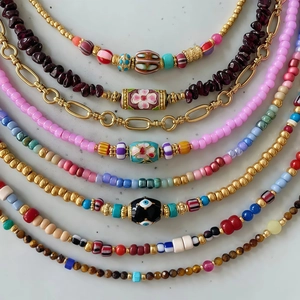 Detalle de collares de cuentas coloridas con motivos de ojo turco y acero inoxidable