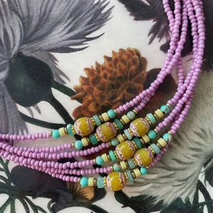Detalle de collar multihilo con cuentas de vidrio coloridas y piedras turquesas de arte