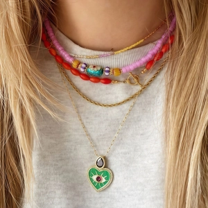 Detalle de collar multicapa de acero inoxidable con cuentas de colores y colgante de ojo