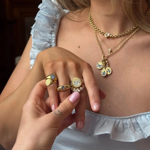 Layered gold necklaces and butterfly rings set with blue enamel and sparkling rhinestones
