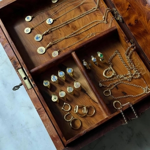 Detail of vintage gold jewelry set with colorful enamel motifs in a walnut display box