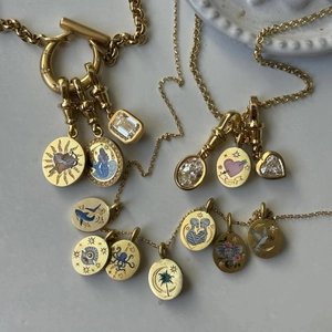 Macro shot of vintage gold necklaces with enamel charms and crystal encrusted pendants