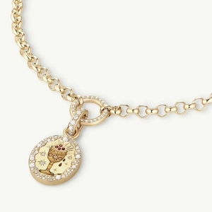 Detail of gold pendant with diamond border and red gemstone grail on a fine chain