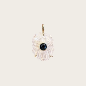 Détail d'un pendentif fleur avec pétales en cristal rose et centre en saphir bleu