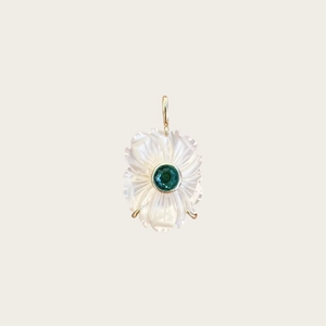 Détail macro du pendentif fleur en nacre avec pierre précieuse verte et fermoir doré