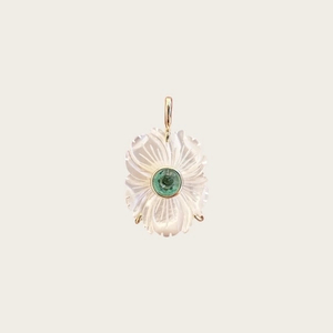 Détail d'un pendentif fleur en nacre blanche avec une gemme verte sur monture dorée