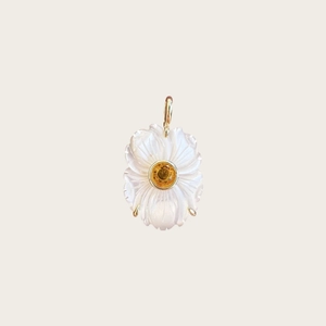 Vue détaillée du pendentif fleur en nacre blanche avec zircon jaune et monture dorée