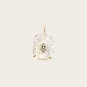 Vue détaillée du pendentif fleur blanche avec monture dorée et zircon central brillant