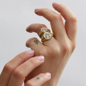 Detail of vintage 18K gold-plated signet rings with hand-painted rabbit and floral motifs