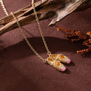Golden necklace with pink ballet slipper pendants and zircon inlay on a vintage base