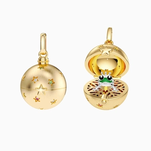 Colgante dorado vintage con estrellas que se abre para mostrar una pequeña rana verde