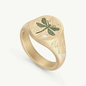 Detailed macro view of gold signet ring with green dragonfly and starry zircons