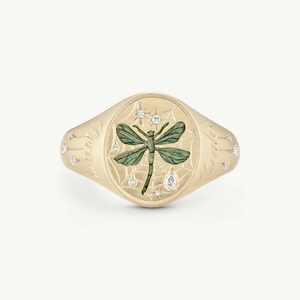 Macro view of gold signet ring with green dragonfly motif and Dream engraving