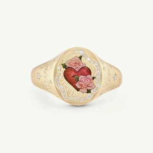 Close-up of golden signet ring with red heart, roses, diamonds and Love engraving