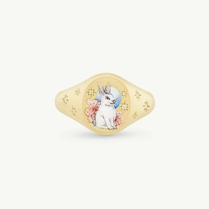 Macro view of gold seal ring featuring enamel rabbit, pink flower and blue moon details