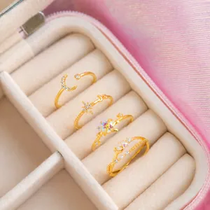Chic 4-piece gold star and moon ring set with sparkling crystals in a jewelry box