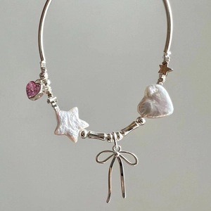 Süßes Silberarmband mit rosa Herzkristall, Sternanhänger und Schleife auf grauem Hintergrund