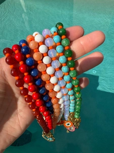 Ensemble de colliers en perles colorées avec pendentifs mauvais œil sur fond d'eau