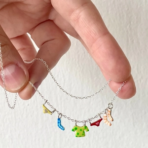 Macro shot of colorful enamel laundry charms on a fine silver necklace chain