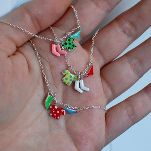 Detailed macro view of silver chains with colorful mini enamel clothes and socks charms