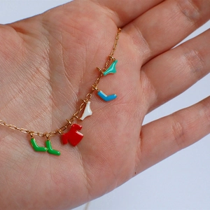 Detail showing creative colorful mini clothing charms on a gold chain necklace