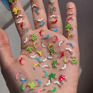 Miniature colorful enamel swimsuit charms held in hand for DIY earring and jewelry making