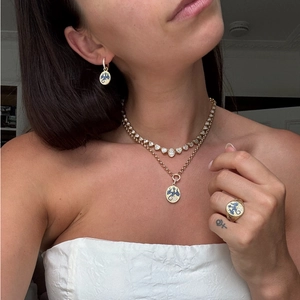 Detalle del collar con colgante de dragón dorado y pendientes usados por una modelo