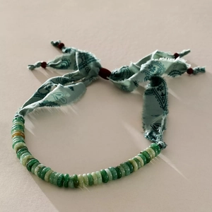 Detail van groene agaat kralen en paisley zijden lint ketting met goudaccenten
