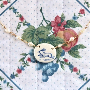 Collana con ciondolo a coniglio in ceramica e perle d'acqua dolce su tessuto fiorito