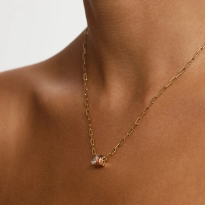 Detalle del collar de cadena de clip dorada con circonitas en forma de pera y rojo-marrón