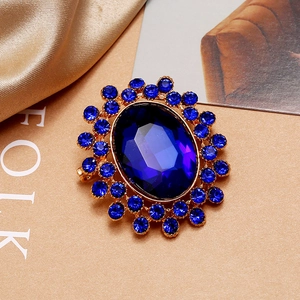 Détail macro d'une broche vintage de luxe avec strass bleus ovales et base dorée