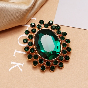 Vue macro d'une broche ovale de luxe en émeraude avec des pierres sur base dorée