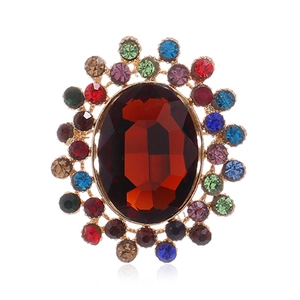 Détail d'une broche vintage avec une grande pierre ovale brun-rouge et cristaux colorés