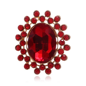 Détail d'une broche vintage dorée avec grand rubis ovale et strass étincelants