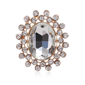Gros plan d'une broche vintage en cristal ovale avec strass étincelants dorés