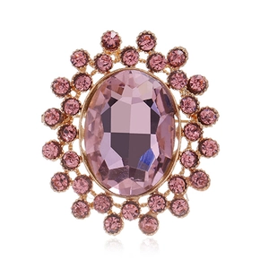 Détail d'une broche vintage de luxe avec gemme ovale violette et cristaux roses fins