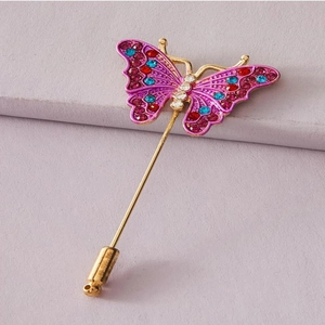 Vue détaillée d'une épingle dorée ornée d'un magnifique papillon en strass colorés