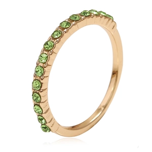 Eleganter vergoldeter Ring mit einer Reihe funkelnder smaragdgrüner Steine auf weißem Grund
