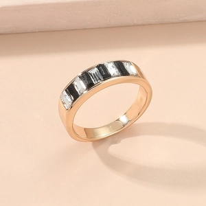 Detailansicht eines vergoldeten Rings mit abwechselnd schwarzen und weißen Schmucksteinen