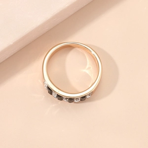 Makroansicht eines roségoldenen Rings mit abwechselnd schwarz-weißen Zirkonia-Steinen