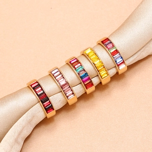 Elegante Ringe mit Baguette-Schliff in leuchtenden Farben auf champagnerfarbener Seide