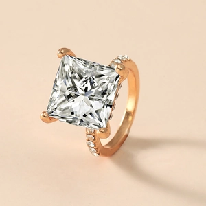 Eleganter roségoldener Ring mit quadratischem Zirkonia im Prinzessschliff und Pavé-Besatz
